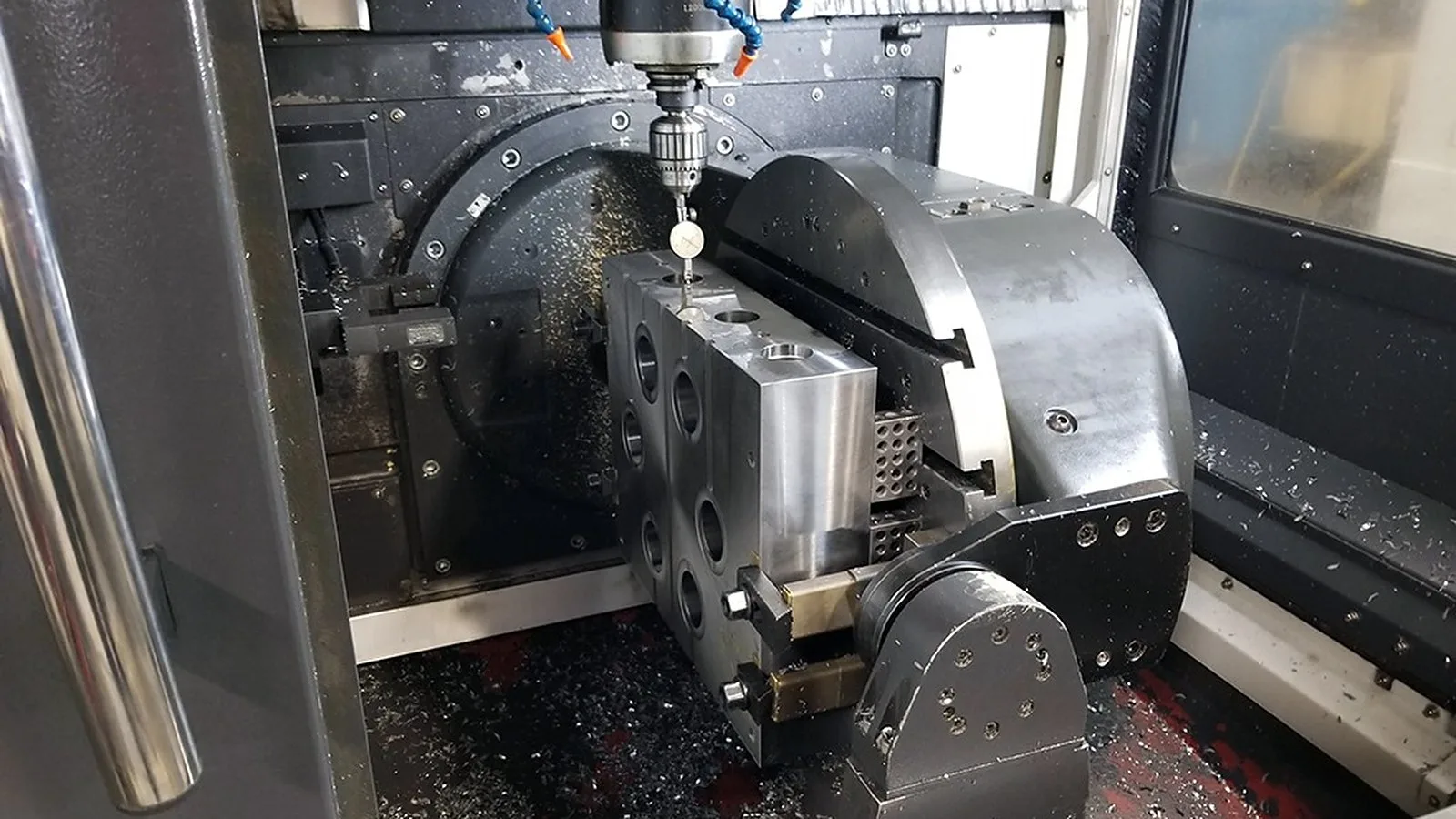 เครื่องกัด CNC หลายแกนกำลังตัดชิ้นงานโลหะในโรงงาน
